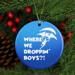 Puede incluir: Un adorno navideño azul y blanco con una silueta de una persona haciendo paracaidismo y el texto "Where We Droppin' Boys?!"