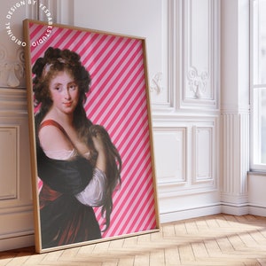 May include: A framed print of a woman with long dark hair wearing a black dress with a red sash. The background is a pink and white striped pattern. The frame is a light wood color.