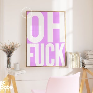 May include: A pink and white framed print with the text "OH FUCK" in white letters on a pink background.