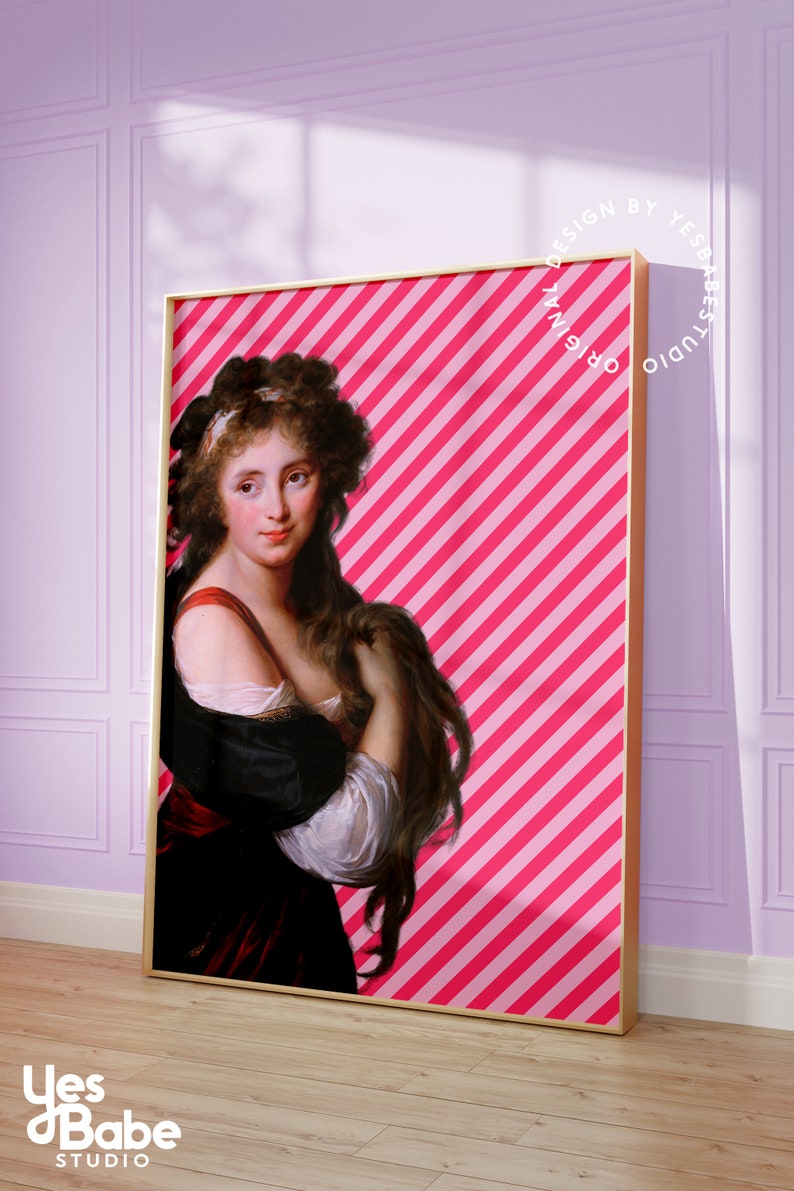 May include: A framed print of a woman with long brown hair wearing a white and black dress against a pink and white striped background. The text "ORIGINAL DESIGN BY YES BABE STUDIO" is printed in a circle around the frame.
