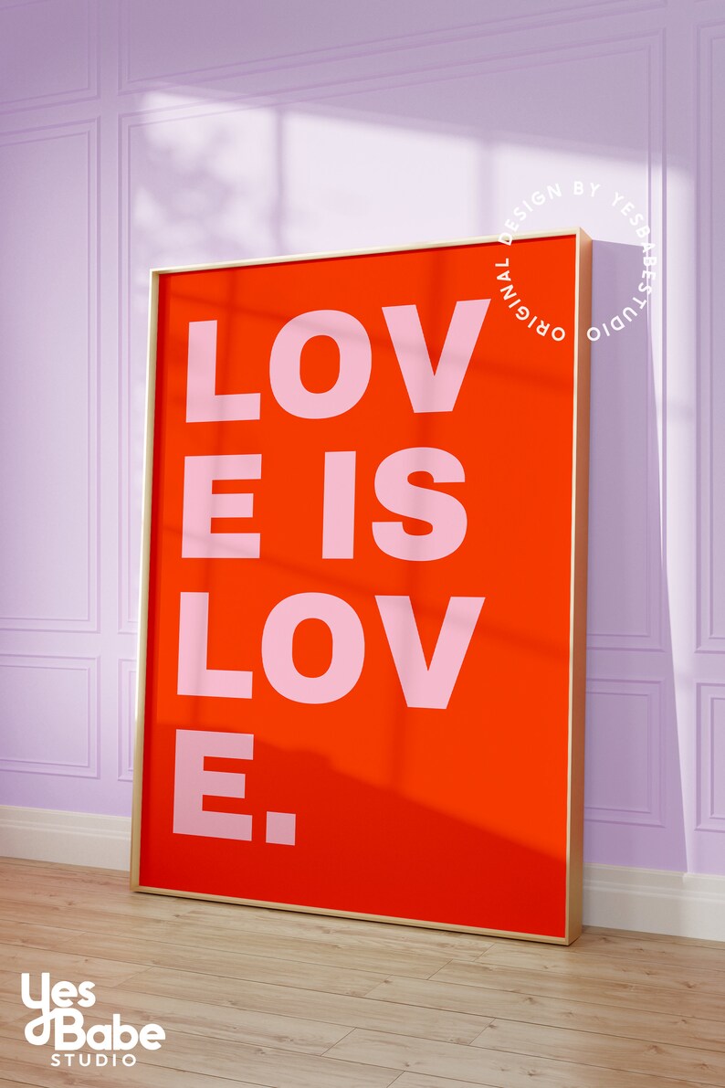 Może przedstawiać: Wydruk w ramie z czerwonym tłem i tekstem "LOVE IS LOVE." w r&oacute;żowych literach. Rama jest złota.