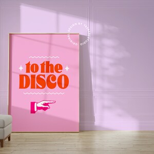 May include: A pink poster with the text "to the disco" in bold orange letters. A white pointing hand is below the text.