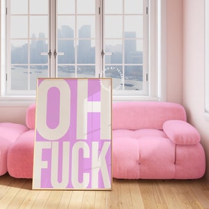 May include: A pink and white framed poster with the text "OH FUCK" in white letters on a pink background.