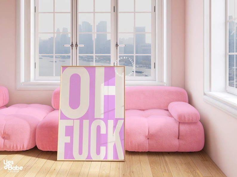May include: A pink and white framed poster with the text "OH FUCK" in white letters on a pink background.