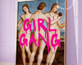 May include: A painting of three women standing together, with the words "GIRL GANG" written in pink spray paint over them. The painting is framed in gold.