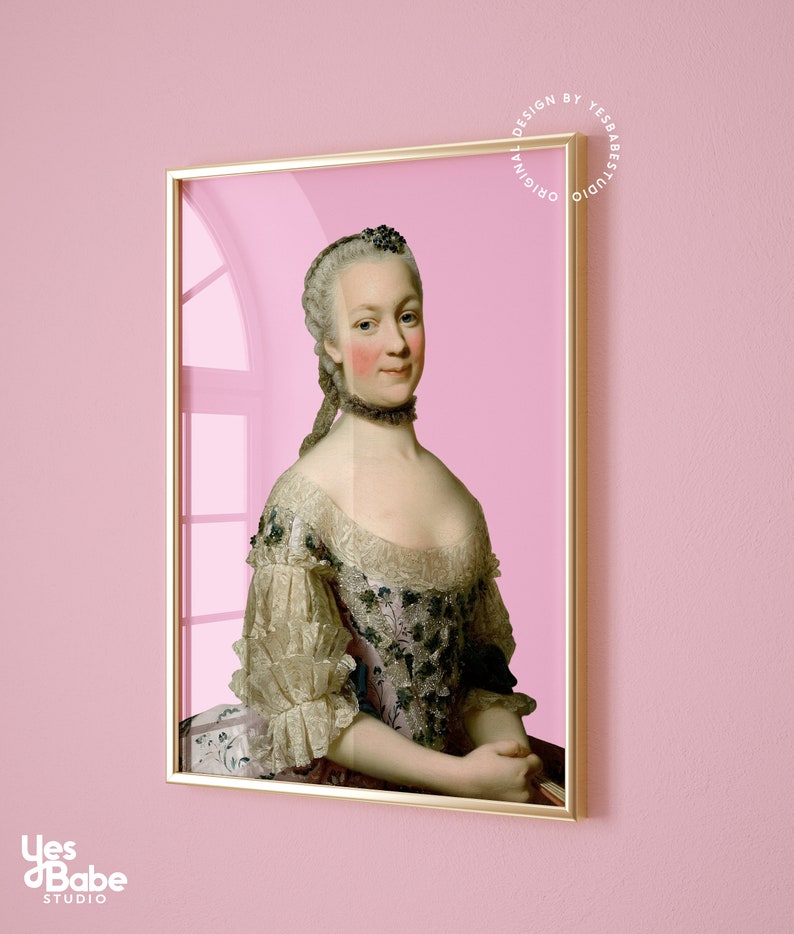 May include: A framed portrait of a woman in a white and pink dress with a lace collar. The woman has a light complexion and is wearing a white wig. The background is a light pink color. The frame is gold.