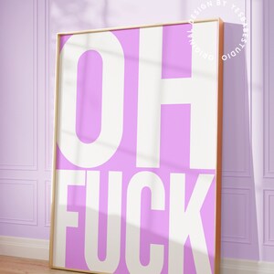 May include: A pink and white framed print with the text "OH FUCK" in white letters on a pink background.
