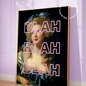 May include: Framed art print featuring a classical portrait of a woman with the word "BLAH" overlaid in pink. The artwork has a gold frame and is displayed against a light purple wall. The print is from Yes Babe Studio.