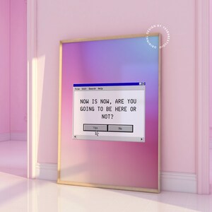 Pu&ograve; includere: Una stampa d'arte digitale con uno sfondo sfumato rosa e viola. La stampa presenta uno schermo di computer vintage con il testo "NOW IS NOW, ARE YOU GOING TO BE HERE OR NOT?" e due pulsanti etichettati "S&igrave;" e "No".
