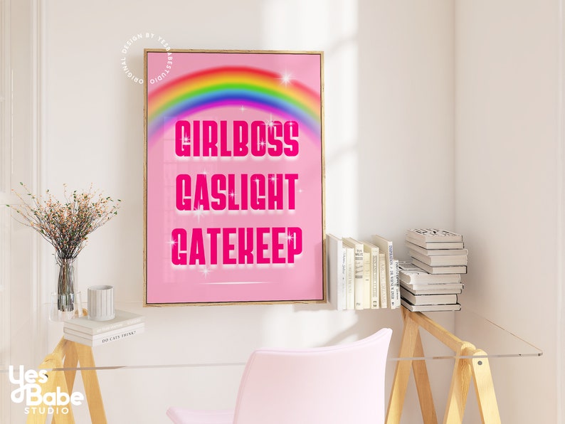 Pu&ograve; includere: Poster rosa e bianco con un arcobaleno e il testo "Girlboss Gaslight Gatekeep" in rosa.