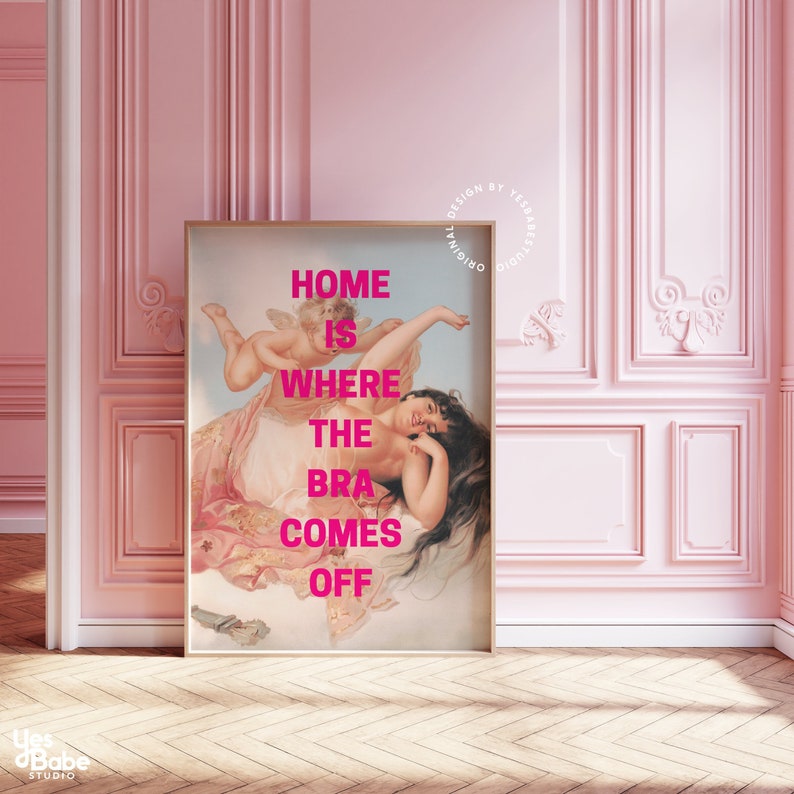 May include: A pink framed print with a painting of a woman reclining on a cloud with a cherub. The text "HOME IS WHERE THE BRA COMES OFF" is printed in pink on the print.