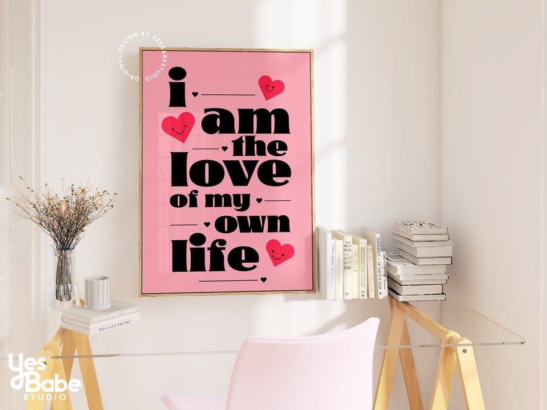 May include: Pink and black typography print with the text "I am the love of my own life" with red hearts with smiley faces.