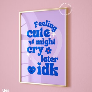 May include: A purple and blue framed print with the text "Feeling cute might cry later idk" in a retro font. The print features a heart with a smiley face and a butterfly.