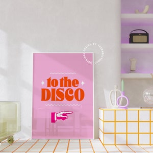 May include: Pink poster with a white border featuring a red and orange graphic that says "to the disco" with a pointing hand. The poster is hanging on a white wall.