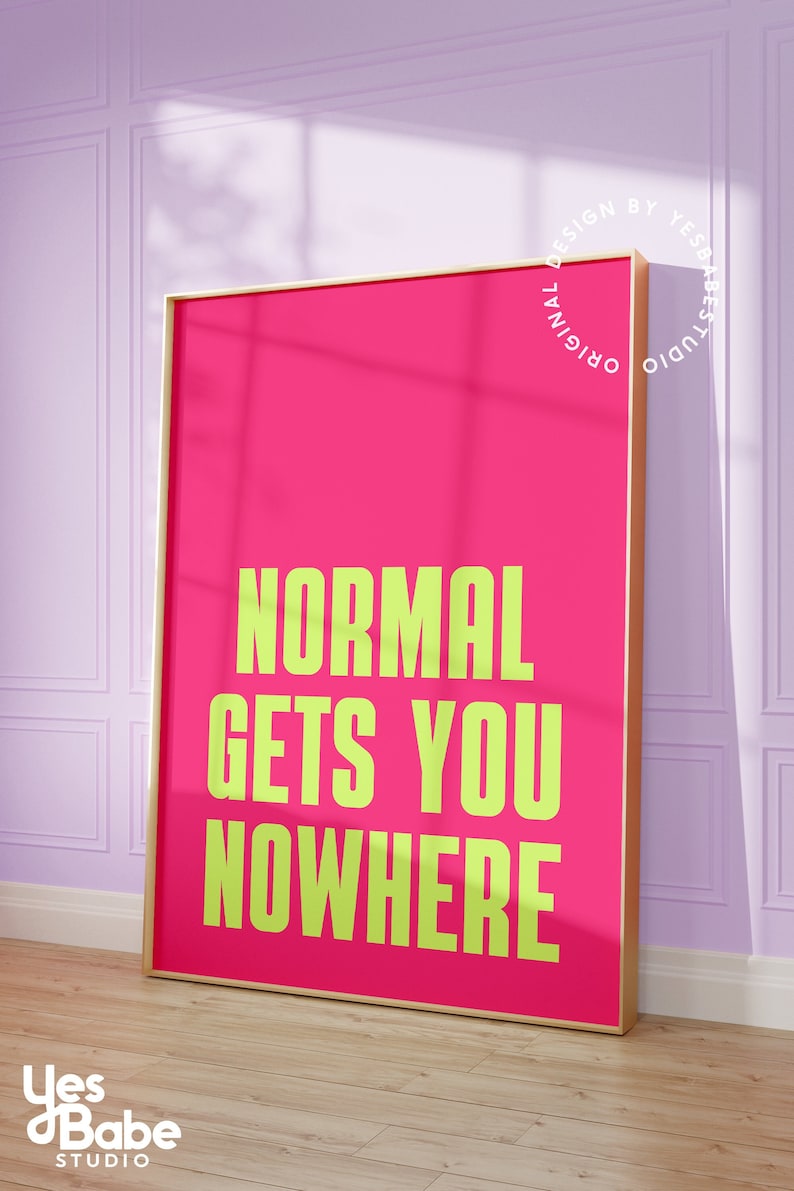 May include: A pink framed print with the text "NORMAL GETS YOU NOWHERE" in yellow lettering. The print is framed in a gold frame and has a white background.