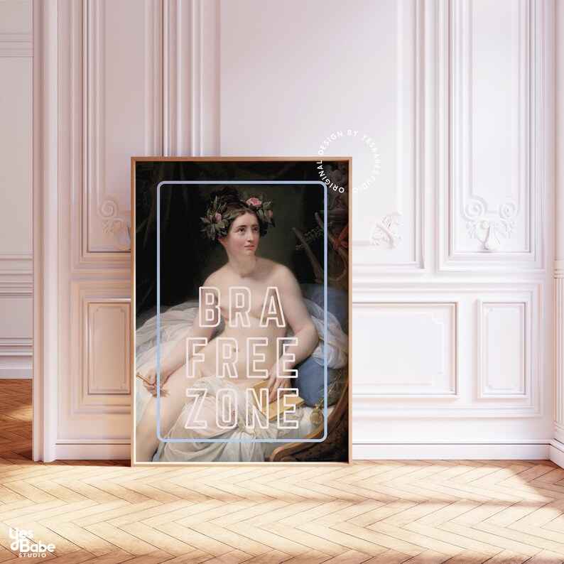 May include: A vintage painting of a woman with a flower crown, sitting on a chair. The painting is framed in a black frame and has the text "BRA FREE ZONE" superimposed on it.
