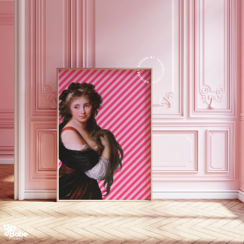 May include: A framed print of a woman with long brown hair wearing a black and red dress against a pink and white striped background. The text "ORIGINAL DESIGN BY YESBABE STUDIO" is printed in a circle around the frame.