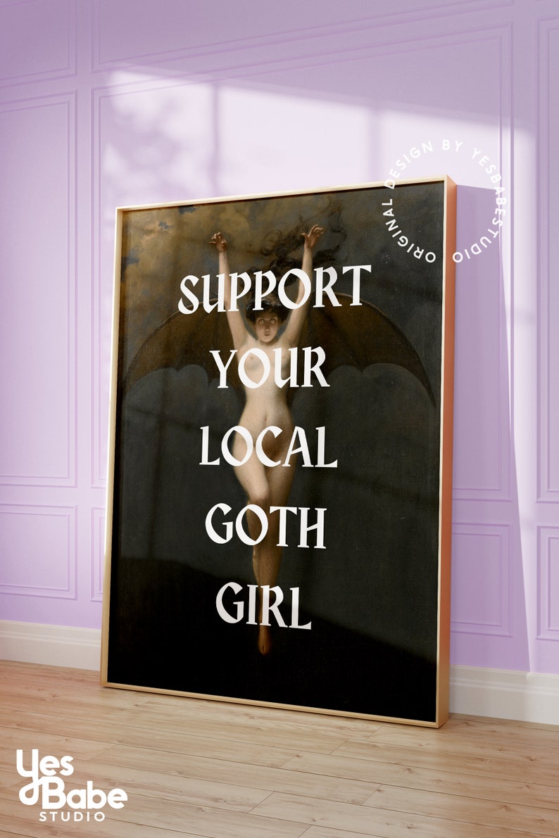 May include: A framed print with a dark background featuring a woman with wings, with the text "SUPPORT YOUR LOCAL GOTH GIRL" in white letters.