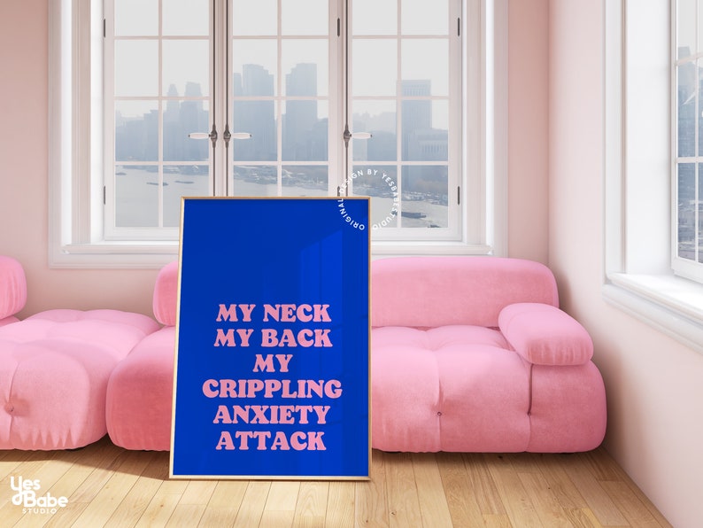May include: A blue poster with pink text that reads "MY NECK MY BACK MY CRIPPLING ANXIETY ATTACK" hanging on a wall in a room with a pink sofa and a window with a city view.