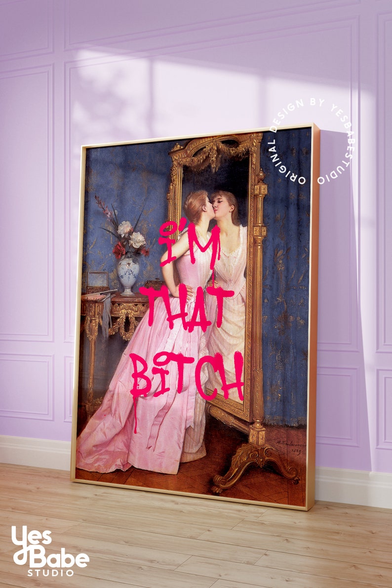 May include: A framed print of a painting of two women in a room with a mirror. The woman in the foreground is wearing a pink dress and the woman in the mirror is wearing a white dress. The text "I'M THAT BITCH" is written in pink letters over the image.