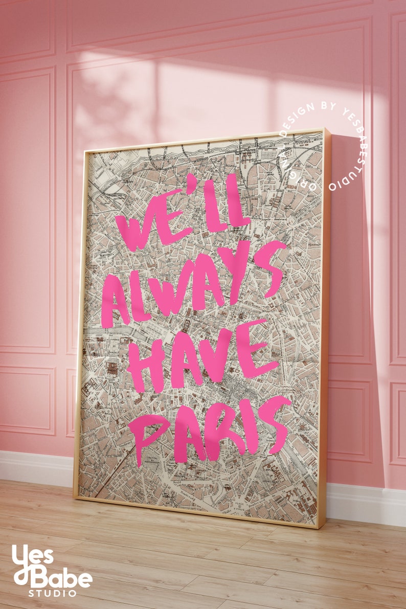 K&ouml;nnte beinhalten: Ein gerahmter Druck mit einer Vintage-Karte von Paris als Hintergrund. Die Worte "We'll Always Have Paris" sind in Pink &uuml;ber die Karte geschrieben.
