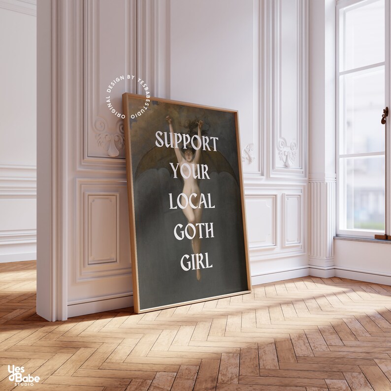 May include: A framed print with a dark background featuring a woman with wings, holding onto a rope. The text "SUPPORT YOUR LOCAL GOTH GIRL" is printed in white on the print.