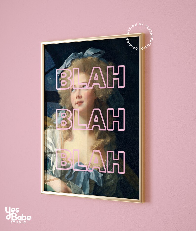 May include: Framed art print featuring a portrait of a woman with a blue bow and dress, overlaid with the word "BLAH" in pink three times. The artwork is in a gold frame, set against a pink wall. The print is from Yes Babe Studio.