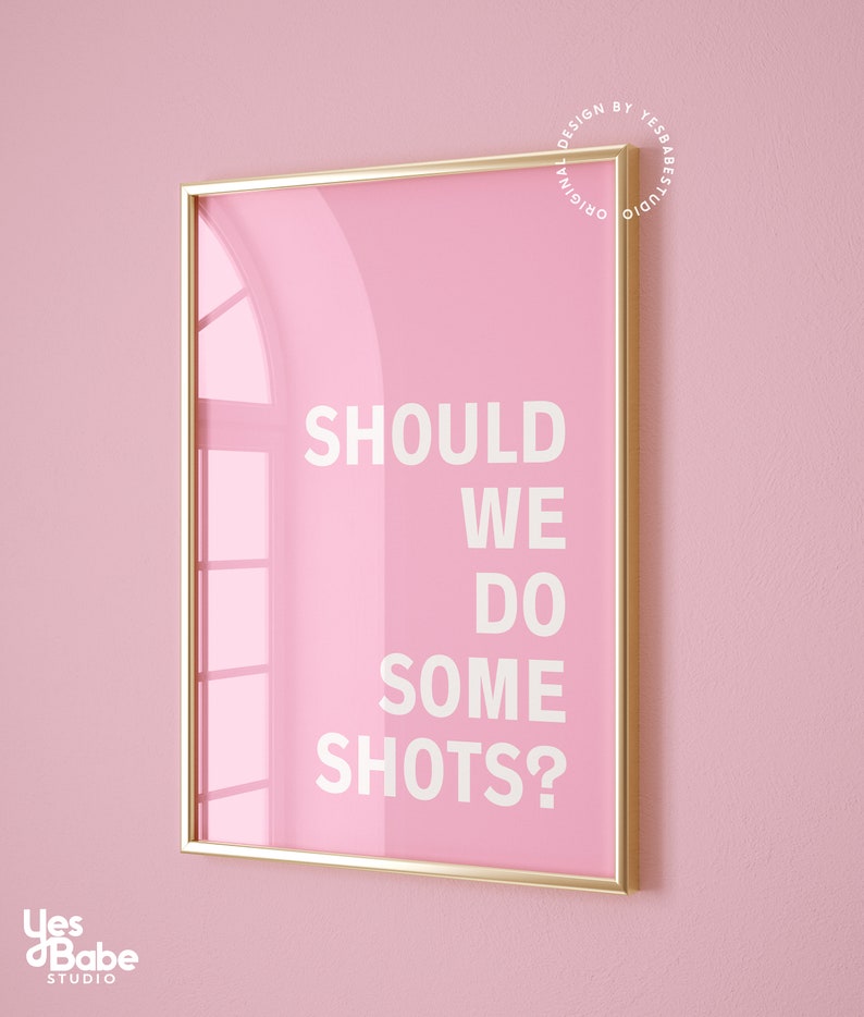 May include: A pink framed poster with gold trim, featuring the text "SHOULD WE DO SOME SHOTS?" in white lettering.