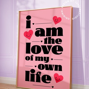 May include: Pink and black typography print with the text "i am the love of my own life" with red hearts with smiley faces.