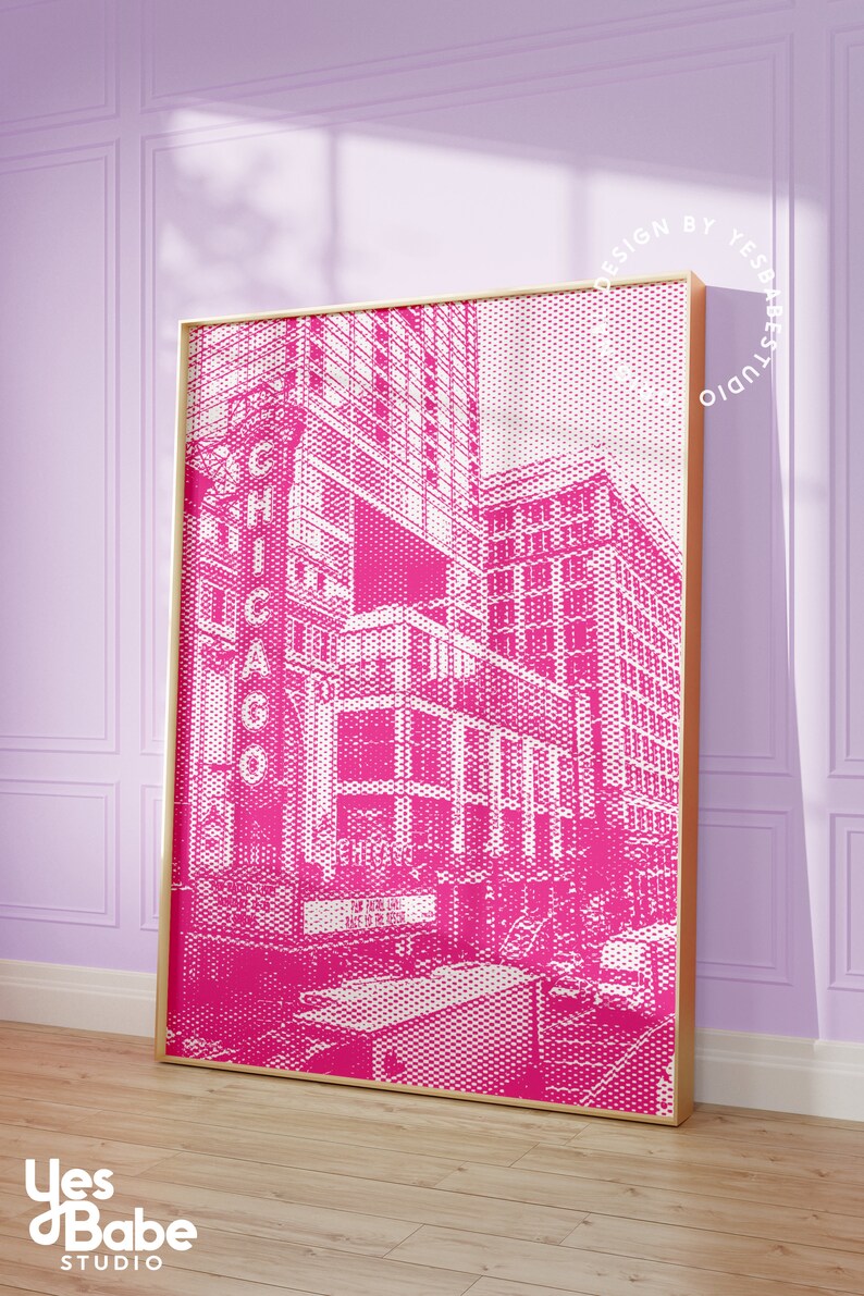 Op de afbeelding: Een ingelijste roze en witte prent van een Chicago stadsgezicht. Het kunstwerk heeft een halftone stippenpatroon, met het woord "CHICAGO" prominent weergegeven. De prent zit in een gouden lijst en leunt tegen een lavendelkleurige muur.