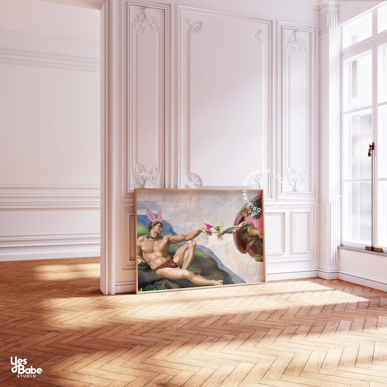 May include: A framed print of a painting depicting two figures, one reclining and the other reaching out with a cocktail. The reclining figure is wearing bunny ears. The painting is set against a white wall with ornate molding.