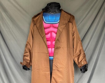 May include: A full-body costume featuring a brown trench coat, a pink and blue chest piece, and blue boots. The costume has black gloves and a black head covering. The outfit is designed to resemble a comic book character.