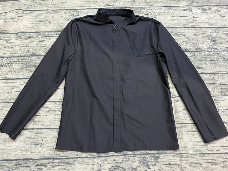 May include: A black long-sleeved shirt with a mandarin collar and a button-up front.