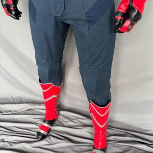 Puede incluir: Un pantal&oacute;n azul con botas rojas y plateadas. El pantal&oacute;n tiene una tela texturizada y est&aacute; dise&ntilde;ado con un aspecto futurista.