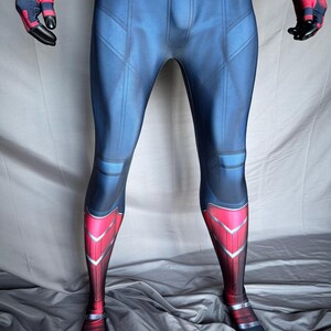 May include: A full-body superhero costume in blue, red, and black. The costume features a blue torso with red accents on the legs and arms. The gloves and feet are black. The design includes geometric patterns and lines.
