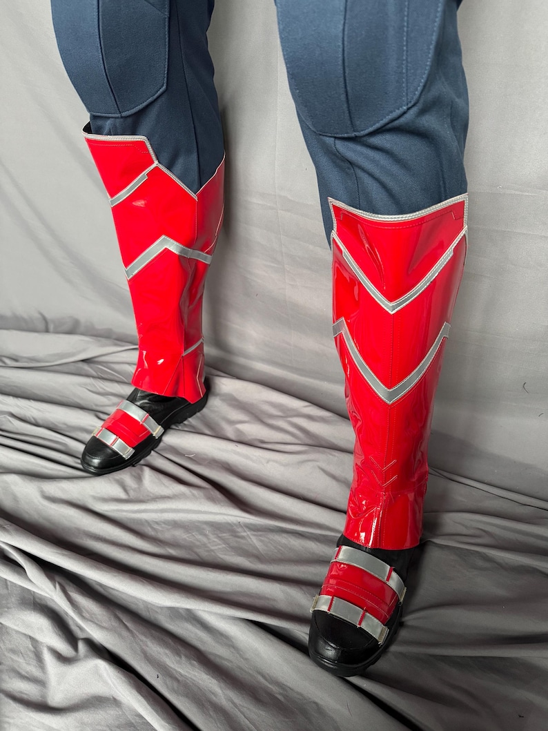 Puede incluir: Botas rojas y plateadas con correas negras. Las botas est&aacute;n hechas de un material brillante y tienen una punta puntiaguda.