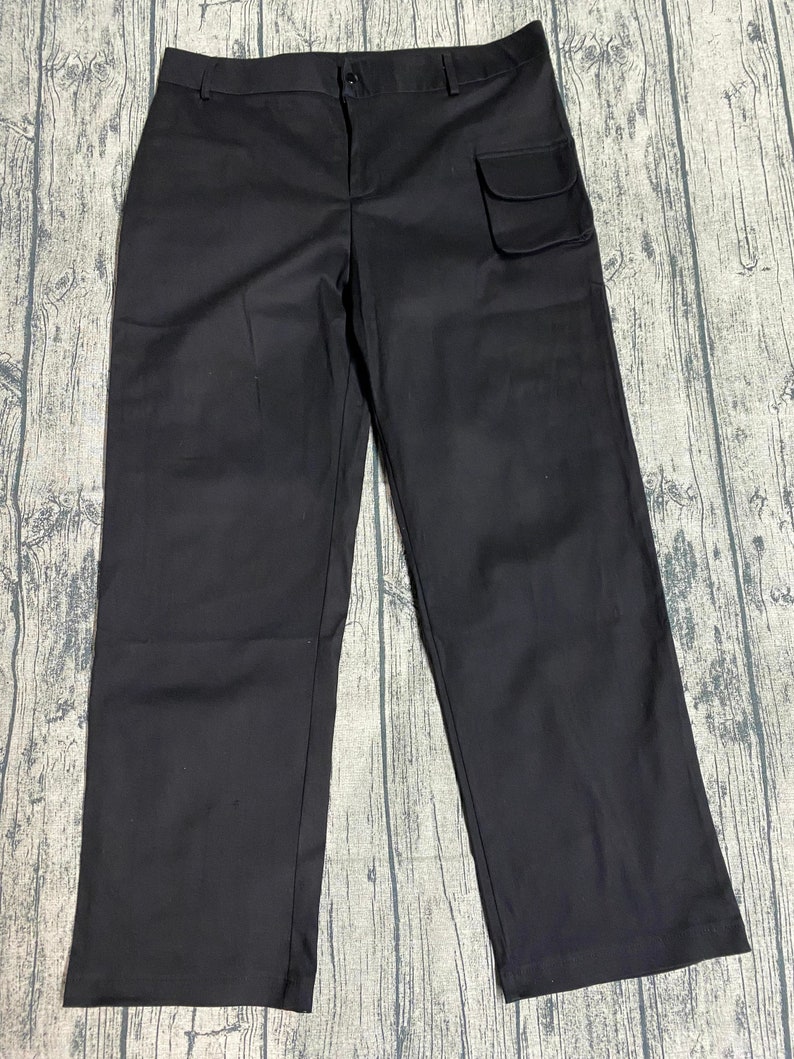 May include: Black cargo pants with a large pocket on the right side.