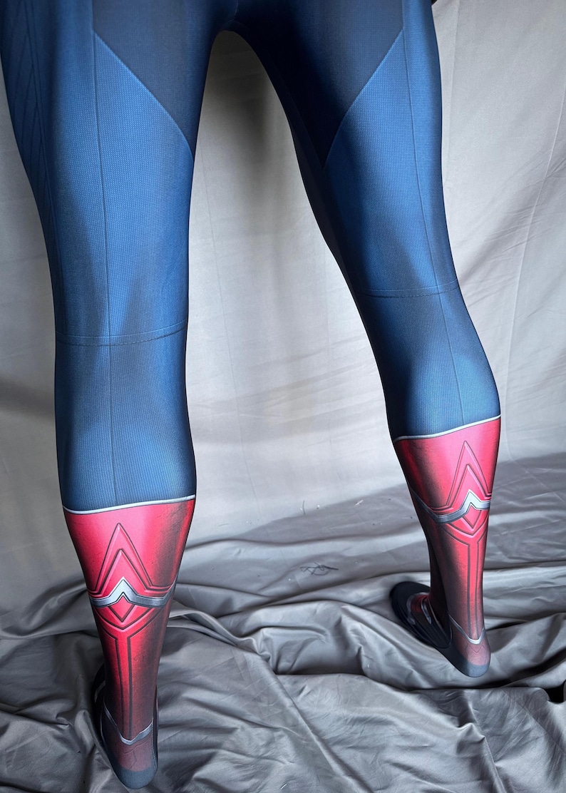 May include: Blue and red leggings with a geometric design on the lower legs. The leggings have a dark blue upper section and a red lower section with silver accents. The fabric appears to be a smooth, stretchy material.