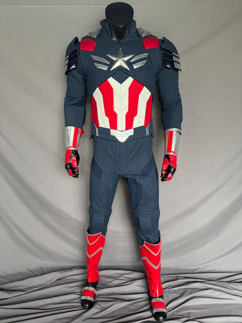 Puede incluir: Un traje de superh&eacute;roe azul y rojo con una estrella plateada en el pecho. El traje incluye una camisa de manga larga, pantalones, guantes y botas.