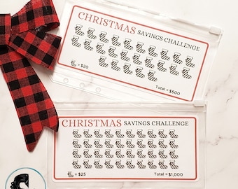May include: Two clear plastic zippered pouches with Christmas savings challenge trackers. The top pouch has 25 stocking icons with a value of £20 each for a total of £500. The bottom pouch has 40 stocking icons with a value of £25 each for a total of £1,000.