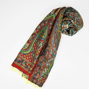 Puede incluir: Una bufanda de seda con estampado paisley rojo, verde y amarillo con flecos.
