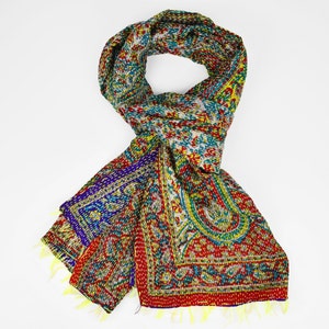 Puede incluir: Una bufanda de seda colorida con un patr&oacute;n de paisley en tonos de rojo, verde, azul y amarillo. La bufanda est&aacute; doblada y atada en un lazo.