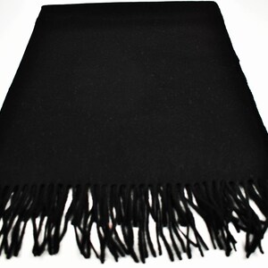 May include: A black scarf with a fringe border. The scarf is made of a soft, warm material and is perfect for keeping you warm in the winter.