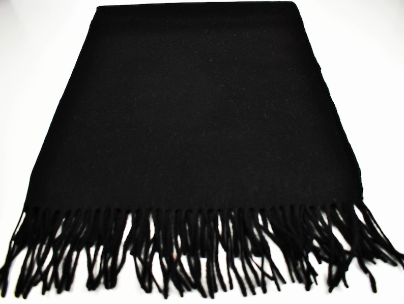 May include: A black scarf with a fringe border. The scarf is made of a soft, warm material and is perfect for keeping you warm in the winter.