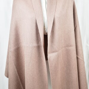 May include: A soft, light brown shawl with a fringed edge. The shawl is made of a fine, lightweight fabric and is perfect for adding a touch of warmth and style to any outfit.