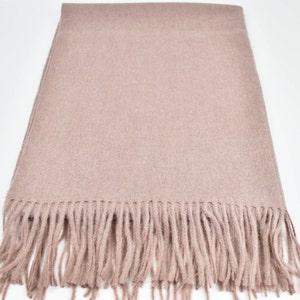 May include: A soft, light pink scarf with a fringe border. The scarf is made of a fine, woven fabric.