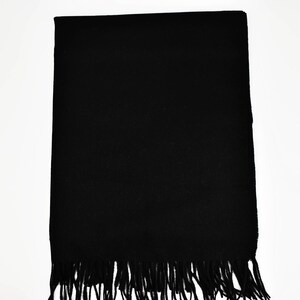May include: A black scarf with a fringe border.