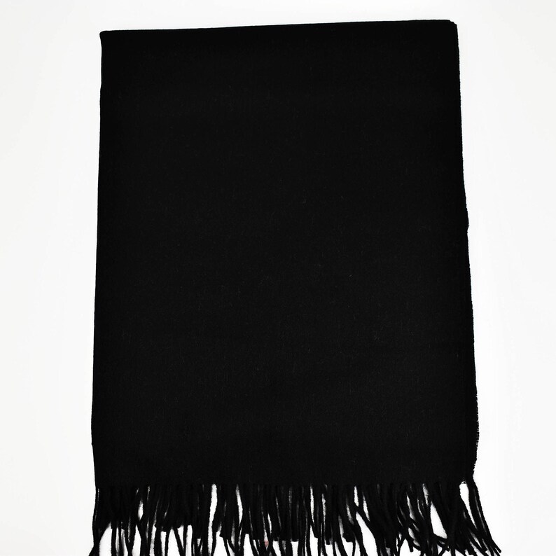 May include: A black scarf with a fringe border.