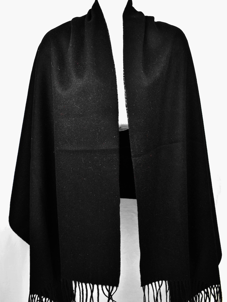 May include: A black pashmina scarf with fringe on the ends.