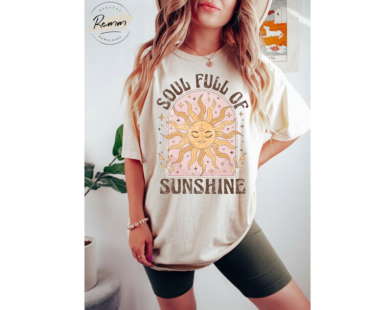 Puede incluir: Una camiseta beige con un gr&aacute;fico de un sol con cara y el texto "Soul Full of Sunshine".